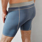 male model wearing confident male blue underwear long boxer briefs with gray band and dribble guard technology wicking layers for men who suffer from benign prostatic hyperplasia or bph